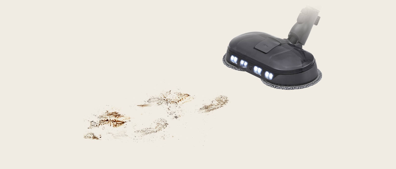 LG vacuum cleaner head with LED lights, efficiently cleaning muddy footprints on a light beige floor.